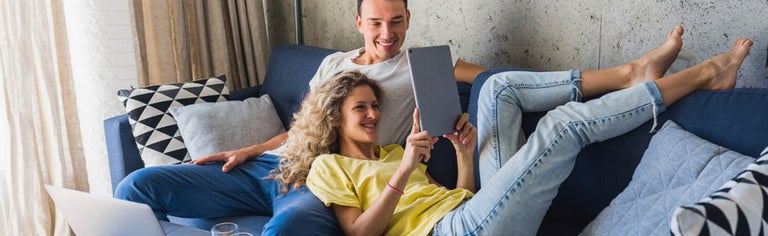 Young couple watching tablet together at home