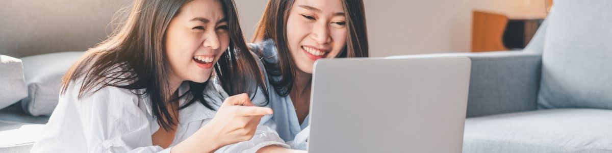 Two friends using a laptop