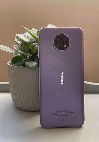 Back of purple Nokia G10 next to pot plant