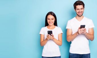 Woman and man looking at phones against blue background