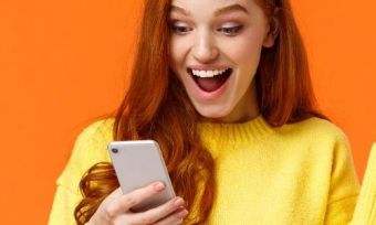 A person looking at a phone excitedly