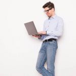 Young man with glasses using laptop