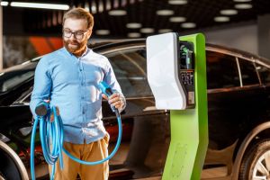 Man at electric vehicle charging station