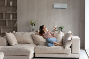 woman sitting on the couch with the air conditioner on