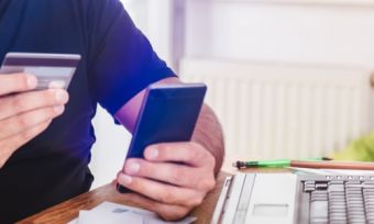 Man looking at credit card while on the phone