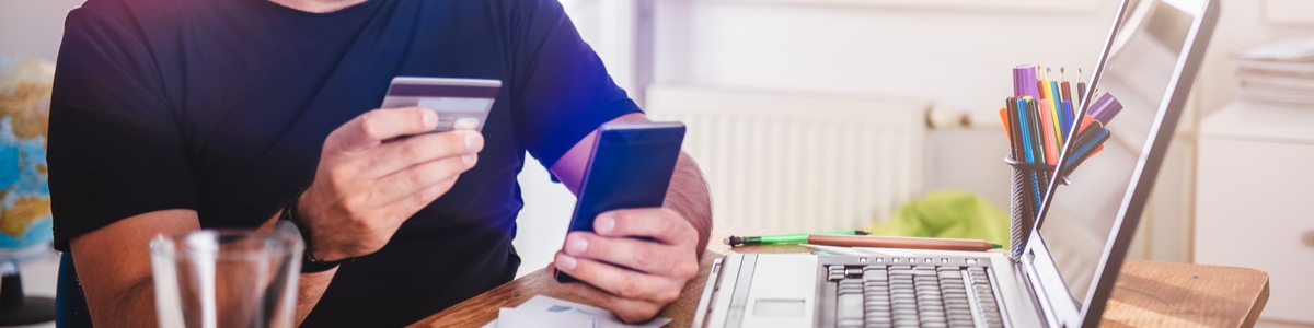 Man looking at credit card while on the phone