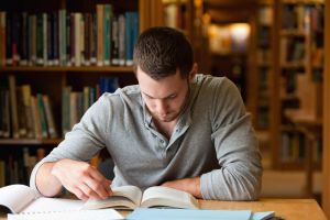 Male student studying in library