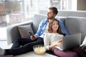 Couple watching show on laptop and TV