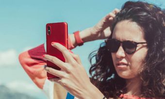 Woman looking at phone trying to find network coverage outdoors