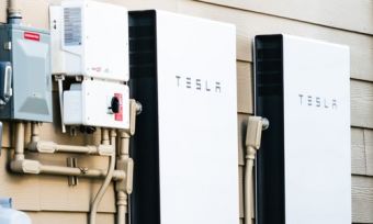 Tesla solar battery in home next to energy meter