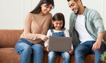 Happy young family using laptop together