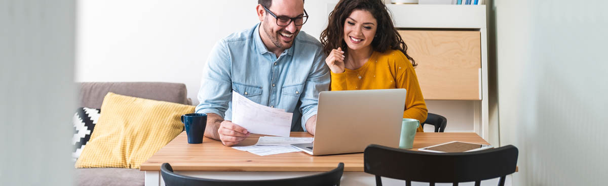 Couple paying bills online at home