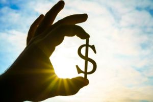 Hand with money symbol and sunlight in background