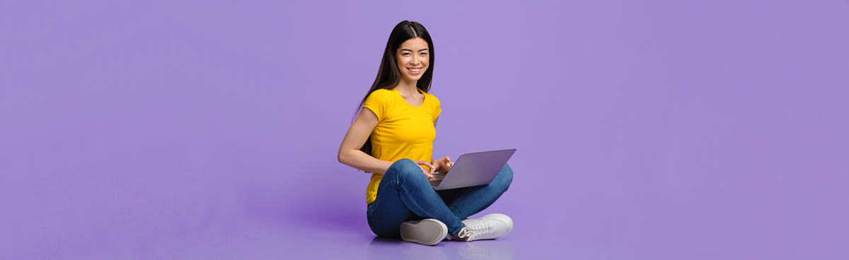 Smiling young woman using internet with purple background