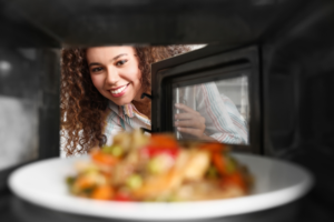 woman looking into microwave