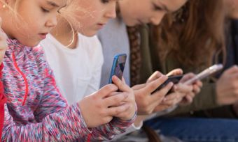 Group of kids looking at smartphones