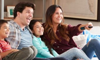 Happy family sitting on lounge watching TV