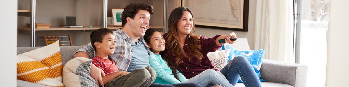 Happy family sitting on lounge watching TV