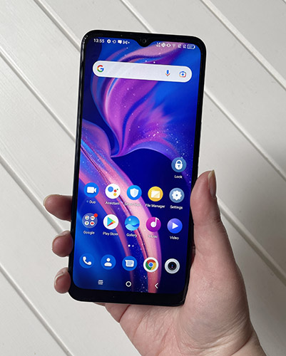 Person holding TCL 20 R 5G phone showing phone screen