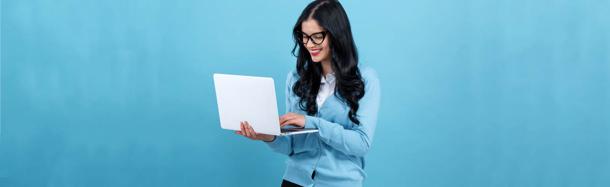 Happy young woman using laptop with blue background