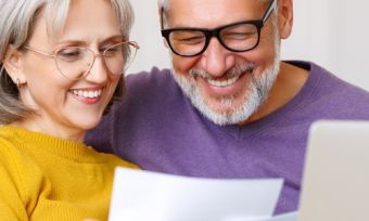 Old couple looking happily at their bills