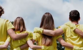 Volunteers in yellow shirts standing with arms linked