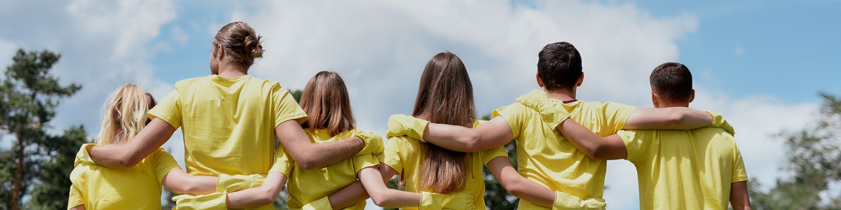 Volunteers in yellow shirts standing with arms linked