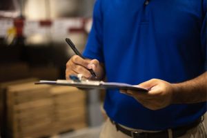 Person holding checklist in a blue shirt 