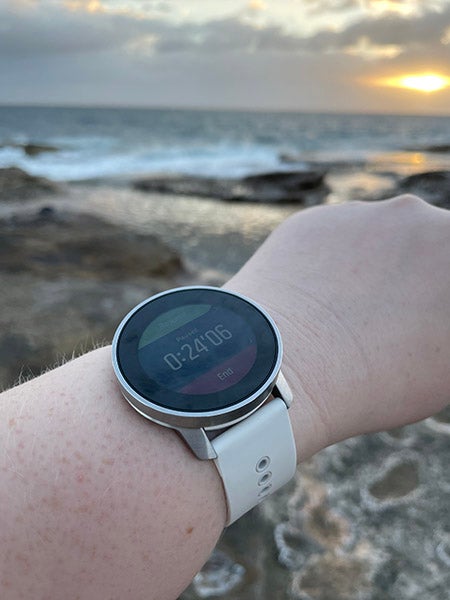Arm wearing Suunto 9 Peak watch with ocean in background