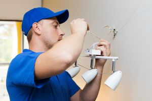 Electrician working on wall light