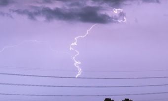 Storm cloud with lighting bolt above a powerline