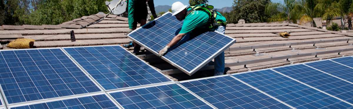 Men installing solar panels on roof