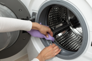 person cleaning washing machine seal