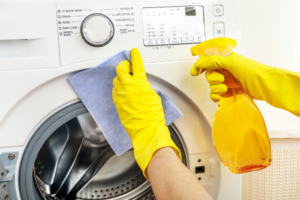 person wiping exterior of washing machine