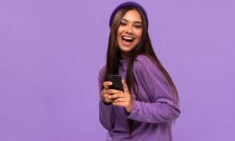 Young woman in purple holding mobile phone