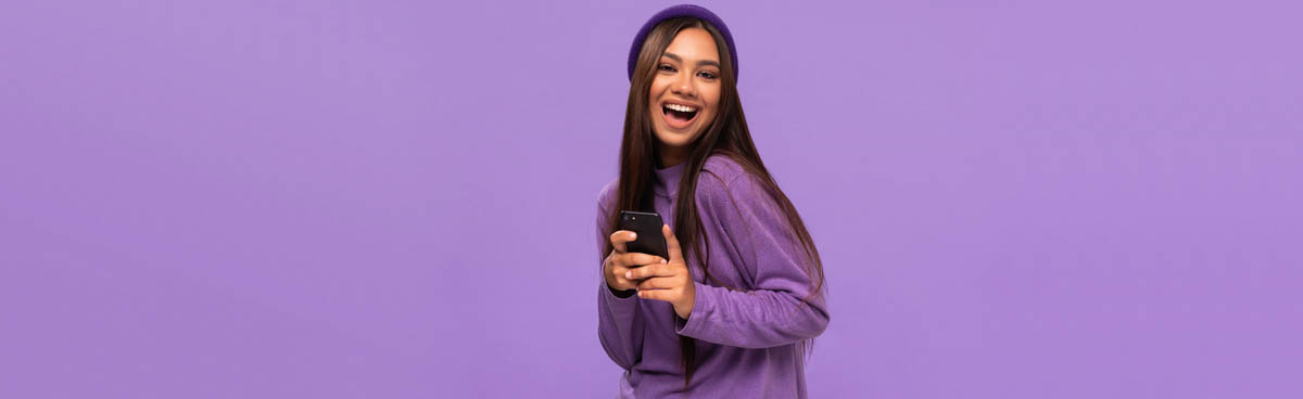 Young woman in purple holding mobile phone