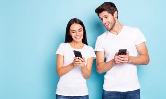 Woman and man looking at phones against blue background