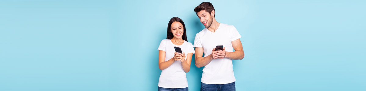 Woman and man looking at phones against blue background