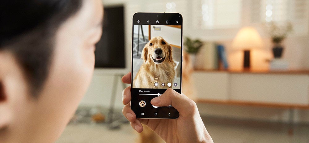 Woman taking photo of dog on Samsung Galaxy S22