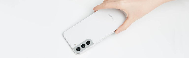Hand holding white Samsung GalaxyS22 phone