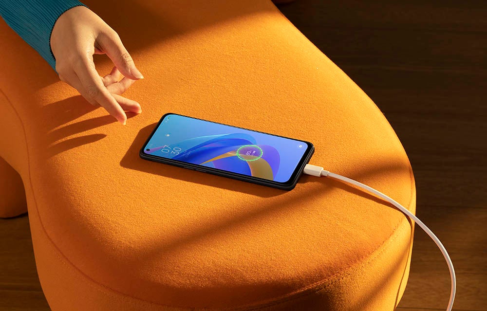 OPPO phone on a charger on orange chair