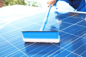 Cleaning solar panels with brush