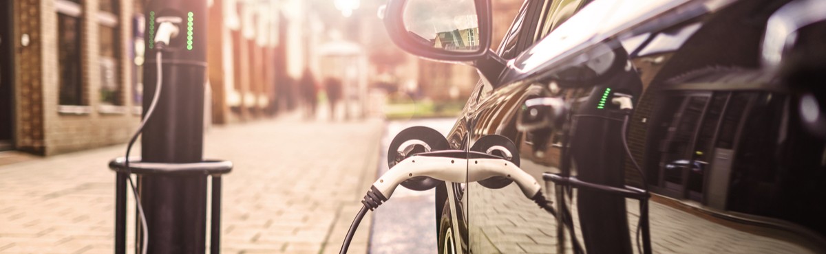 Black electric vehicle charging on the street