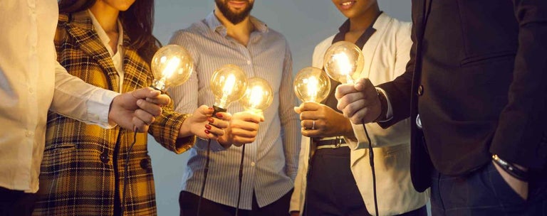 People holding light bulbs in centre