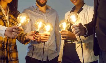 People holding light bulbs in centre