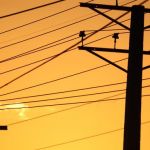 Electricity power lines and grid with sunset background