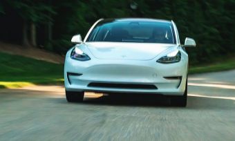 Tesla electric vehicle driving on road