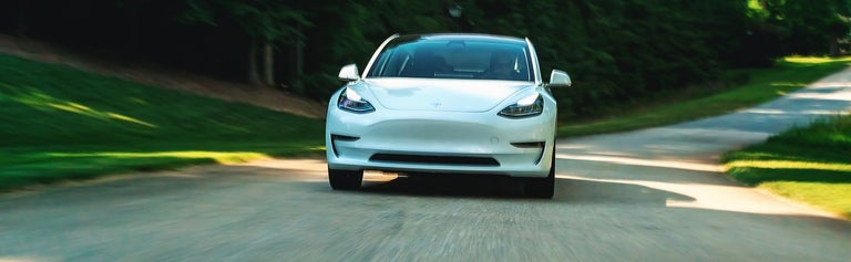 Tesla electric vehicle driving on road