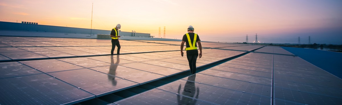 Technicians walking on rooftop with solar panels