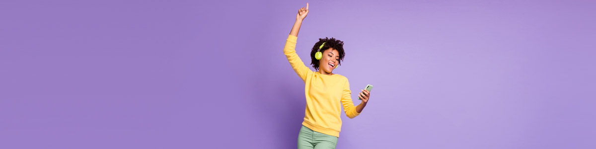 Woman listening to music and holding phone against purple background